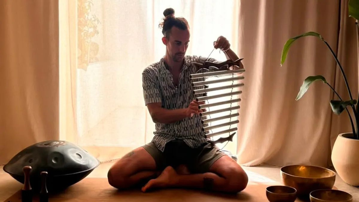 Ram Peris tocando handpan y carillón junto a cuencos tibetanos en una sala luminosa